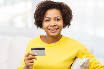 Image showing happy african woman with credit or debit card