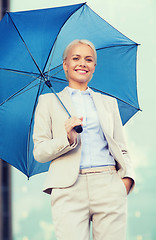 Image showing young smiling businesswoman with umbrella outdoors