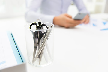 Image showing close up of cup with scissors and pens at office