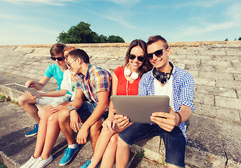 Image showing group of smiling friends with tablet pc outdoors