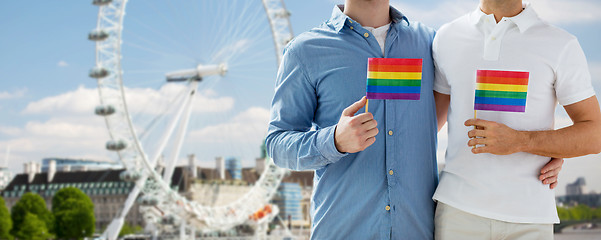 Image showing close up of male gay couple with rainbow flags