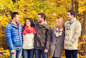 Image showing group of smiling men and women in autumn park