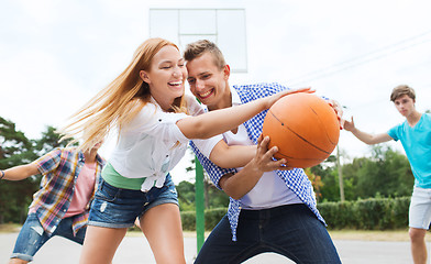 Image showing group of happy teenagers playing basketball