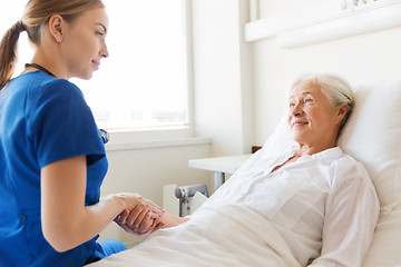 Image showing doctor or nurse visiting senior woman at hospital