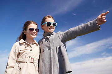 Image showing happy little girls hugging and pointing finger