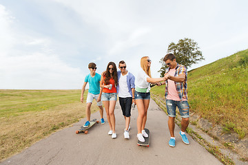 Image showing happy teenage friends with longboards outdoors