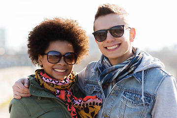 Image showing happy teenage friends in shades hugging outdoors