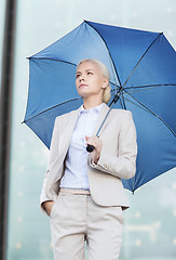 Image showing young serious businesswoman with umbrella outdoors