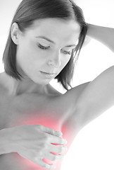 Image showing woman checking breast for signs of cancer