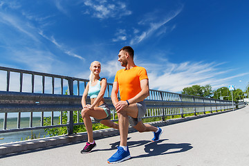 Image showing smiling couple stretching outdoors