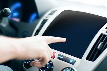 Image showing male hand pointing finger to monitor on car panel