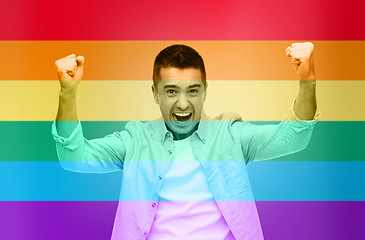 Image showing angry man with raised hands over rainbow flag