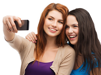 Image showing two smiling teenagers with smartphone