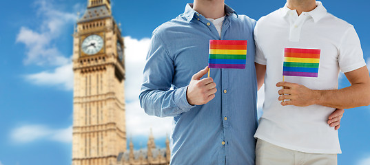 Image showing close up of male gay couple with rainbow flags