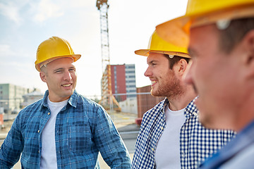 Image showing group of smiling builders in hardhats outdoors