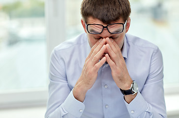 Image showing tired businessman with eyeglasses in office