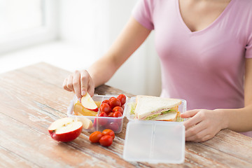 Image showing close up of woman with food in plastic container