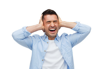 Image showing unhappy man with closed eyes touching his forehead