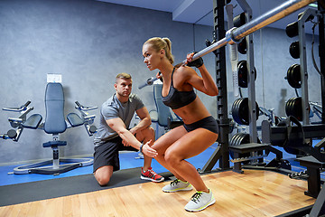 Image showing man and woman with bar flexing muscles in gym