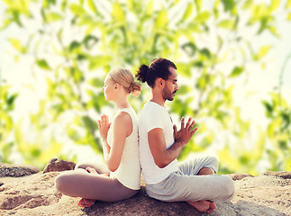 Image showing smiling couple making yoga exercises outdoors