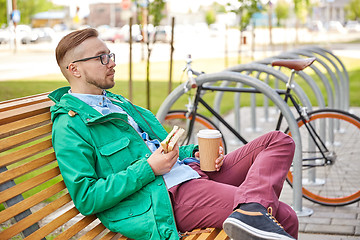 Image showing happy young hipster man with coffee and sandwich
