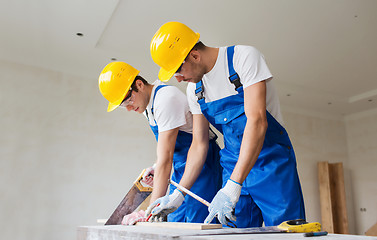 Image showing builders working with arm-saws