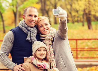 Image showing happy family with camera in autumn park