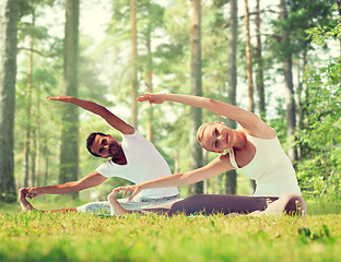 Image showing happy couple stretching and doing yoga exercises