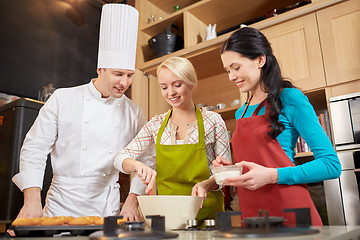 Image showing happy women and chef cook baking in kitchen