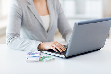 Image showing close up of woman hands with laptop and money