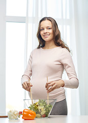 Image showing happy pregnant woman preparing food at home