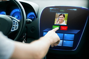 Image showing male hand receiving video call on car panel screen