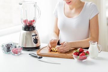 Image showing close up of woman with blender chopping banana