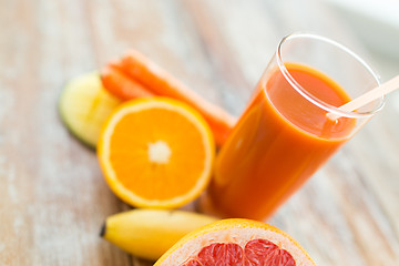 Image showing close up of fresh juice glass and fruits on table