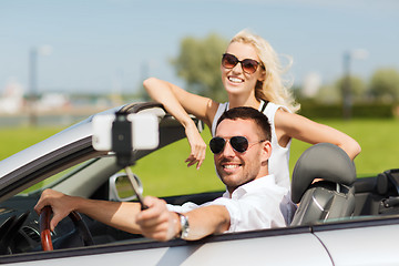 Image showing happy couple in car taking selfie with smartphone