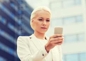 Image showing serious businesswoman with smartphone outdoors