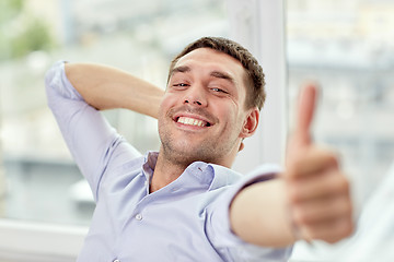 Image showing smiling man showing thumbs up at home or office