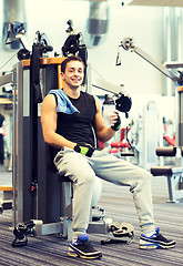 Image showing smiling man exercising on gym machine