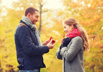 Image showing smiling couple with engagement ring in gift box