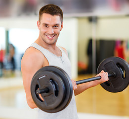 Image showing smiling man with barbell in gym