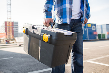 Image showing close up of builder carrying toolbox outdoors