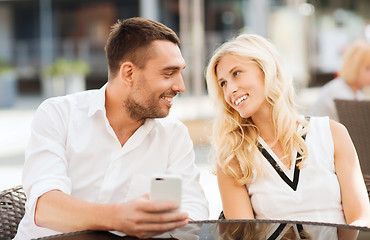 Image showing happy couple with smatphone at city street cafe