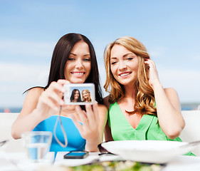 Image showing girls taking photo in cafe on the beach