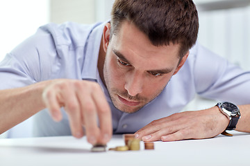 Image showing businessman with coins at office