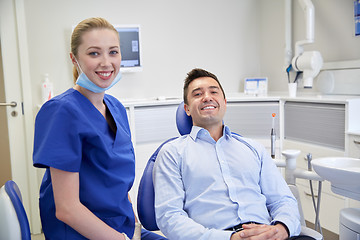 Image showing happy female dentist with man patient at clinic