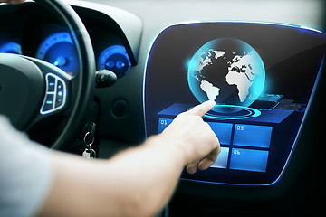 Image showing man hand pointing finger to car monitor with globe