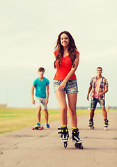 Image showing group of smiling teenagers with roller-skates