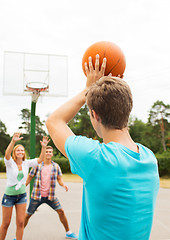 Image showing group of happy teenagers playing basketball