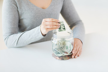 Image showing close up of woman hands and dollar money in jar