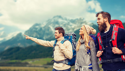 Image showing group of smiling friends with backpacks hiking